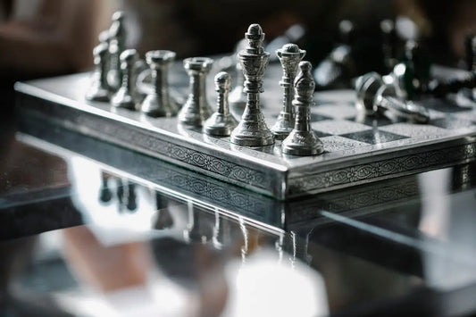 A polished silver chessboard, a symbol of the strategy and observation from the Law of Strategic Silence.