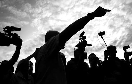 A group of jounalists taking photos and recording an event