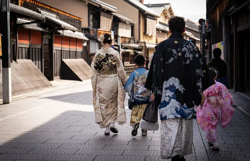Japanese women and children in traditional attire walking down ancient street