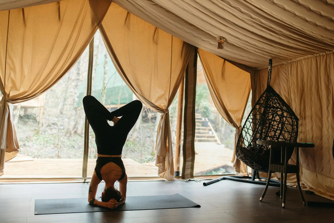 a woman doing head stand yoga pose in a remote retreat